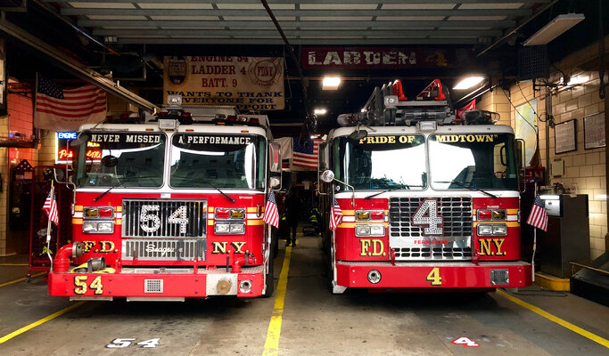 Two Firetrucks Sitting In the Fire Station Garage