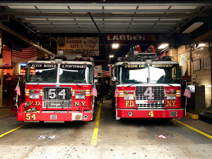 Two Firetrucks Sitting In the Fire Station Garage
